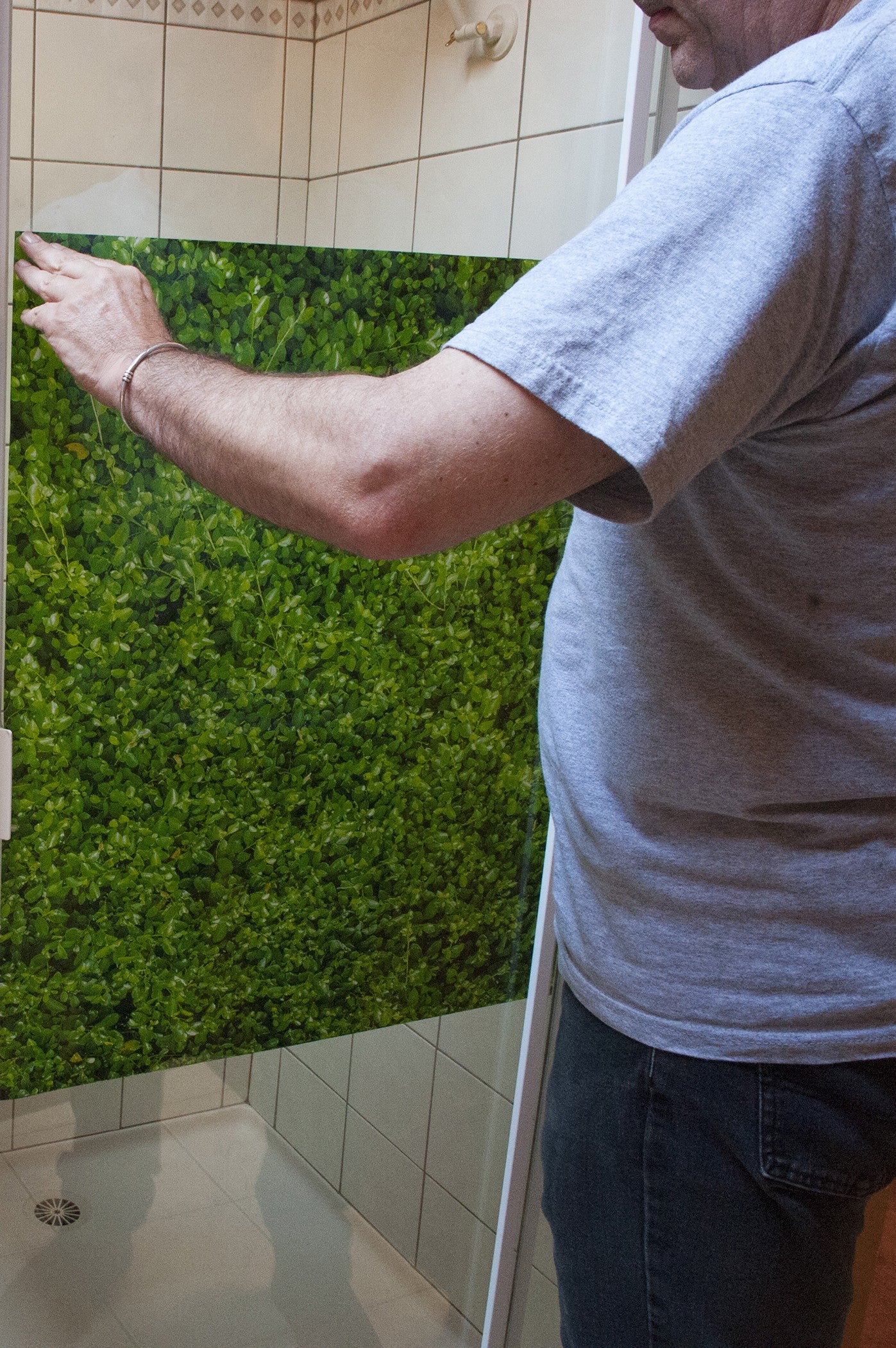 Our inventor, Rory, installing the Leafy Green Shower Screener on shower glass.